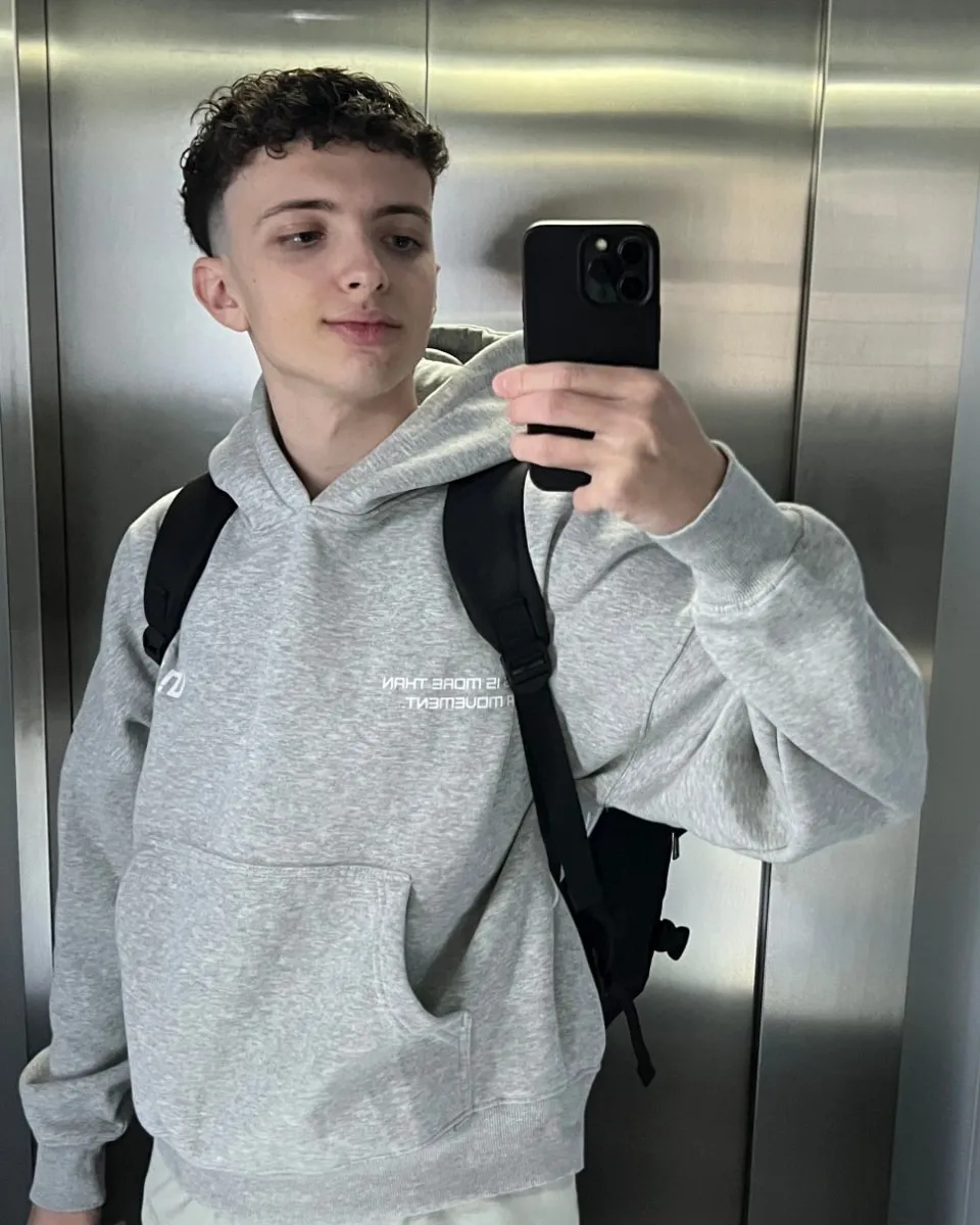 Mauro Valdes haciéndose una foto en el espejo de un ascensor, con sudadera y mochila.